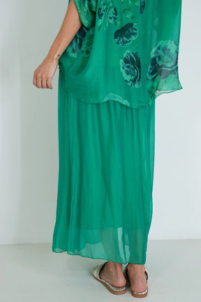 Green dress with floral pattern worn by a person on a white background
