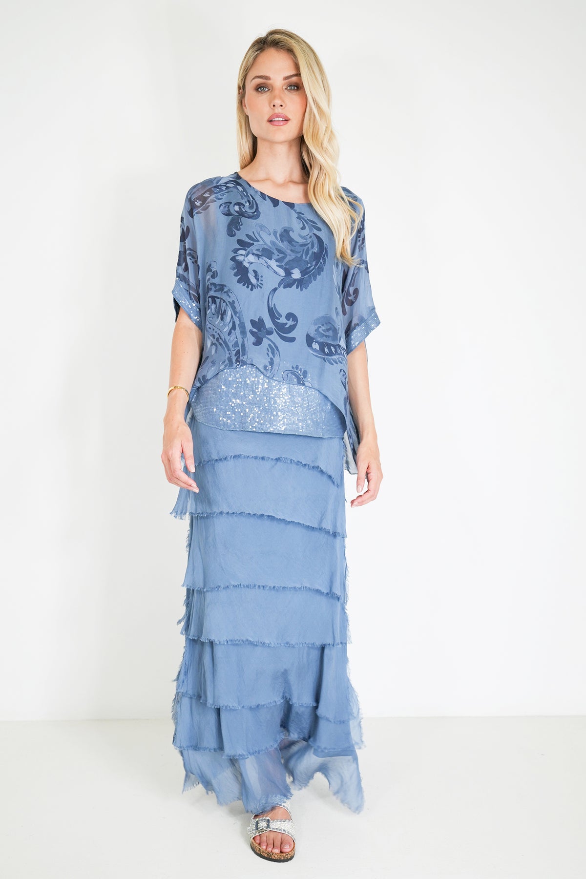 Woman wearing a blue dress with a sequined skirt on a white background