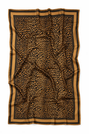 A rectangular scarf with a leopard print pattern in brown and black, featuring a wide tan border with thin black stripes, laid flat on a white background.