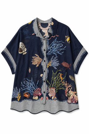 A short-sleeve button-up shirt in navy blue with an all-over embroidered underwater scene, featuring seashells, coral, fish, and sea urchins in various colors, displayed flat against a white background.
