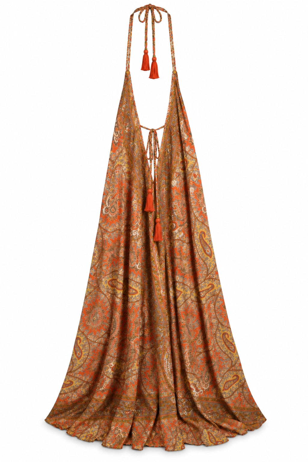 A halter-neck maxi dress with a flowing A-line silhouette, featuring an intricate paisley pattern in rust orange, gold, and brown, with matching tassel ties at the neckline and hem.