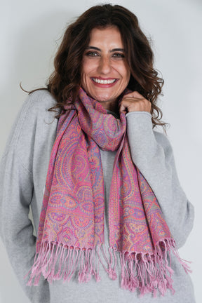 Woman wearing a pink patterned scarf against a white background