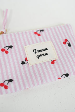 Fabric with pink stripes and cherry pattern, featuring a label with 'Drama queen' text.