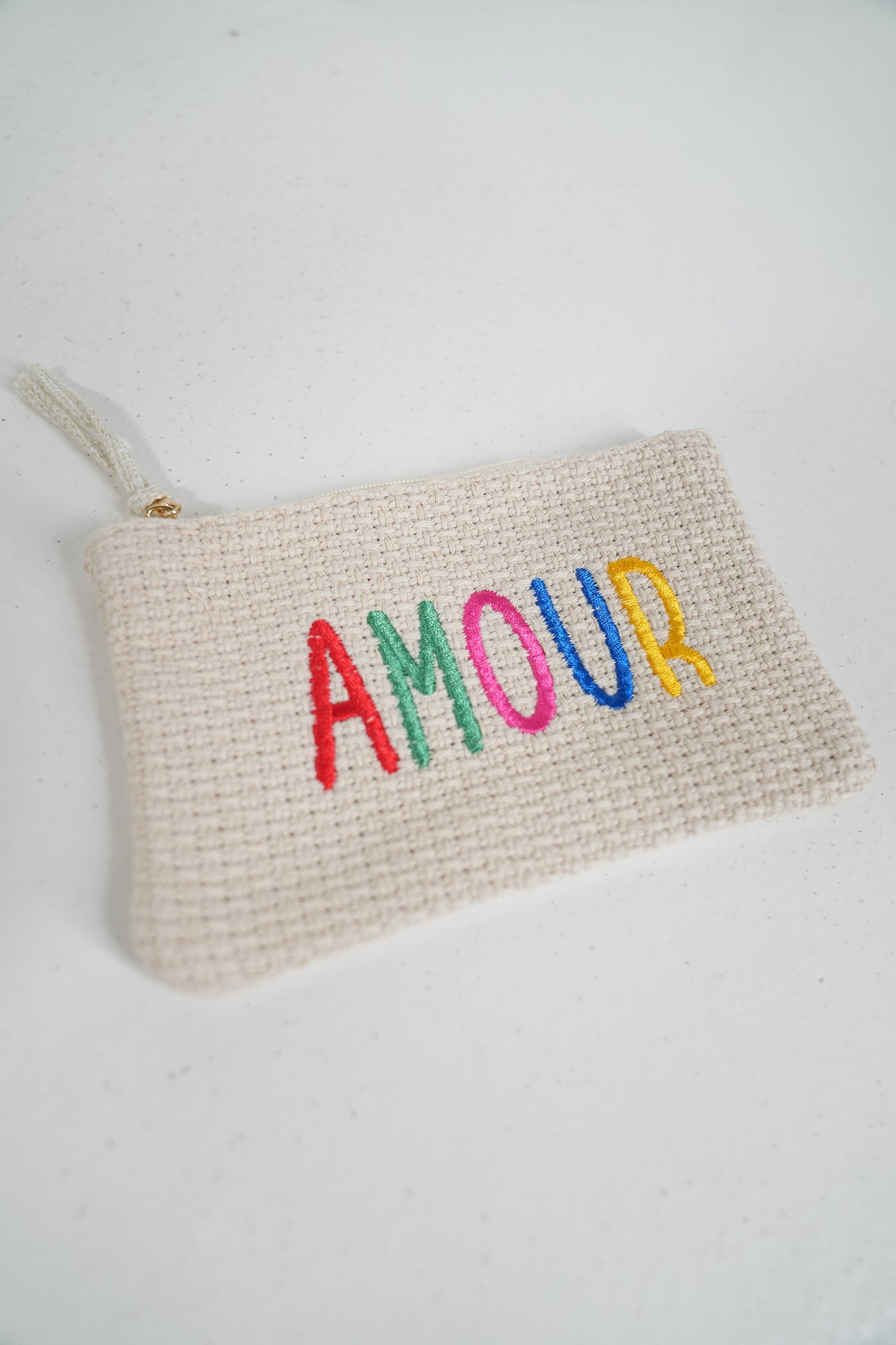 Woven pouch with 'AMOUR' in colorful letters on a white background