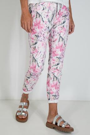 Person wearing pink floral pants on a white background