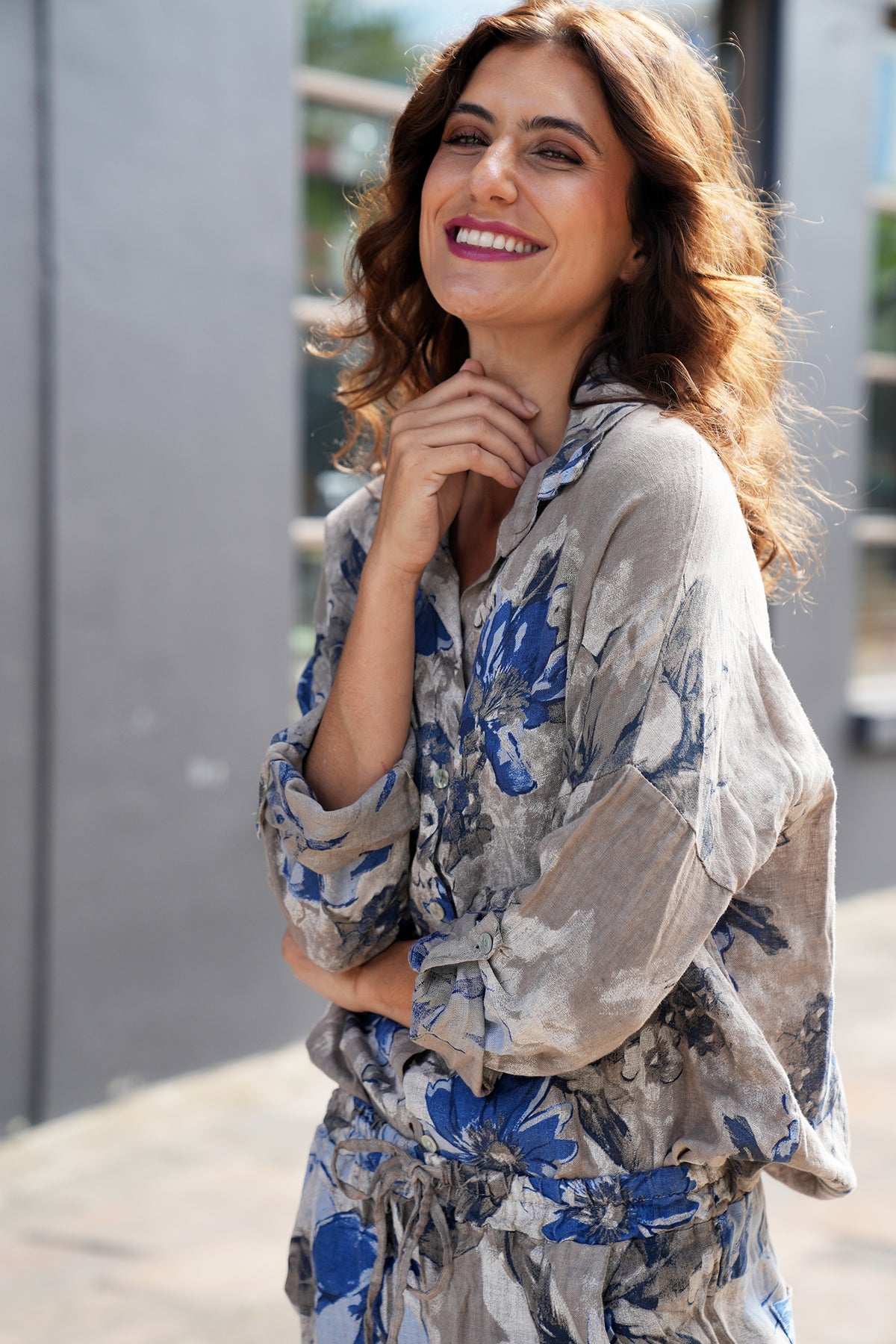 Woman wearing a floral outfit standing outdoors.