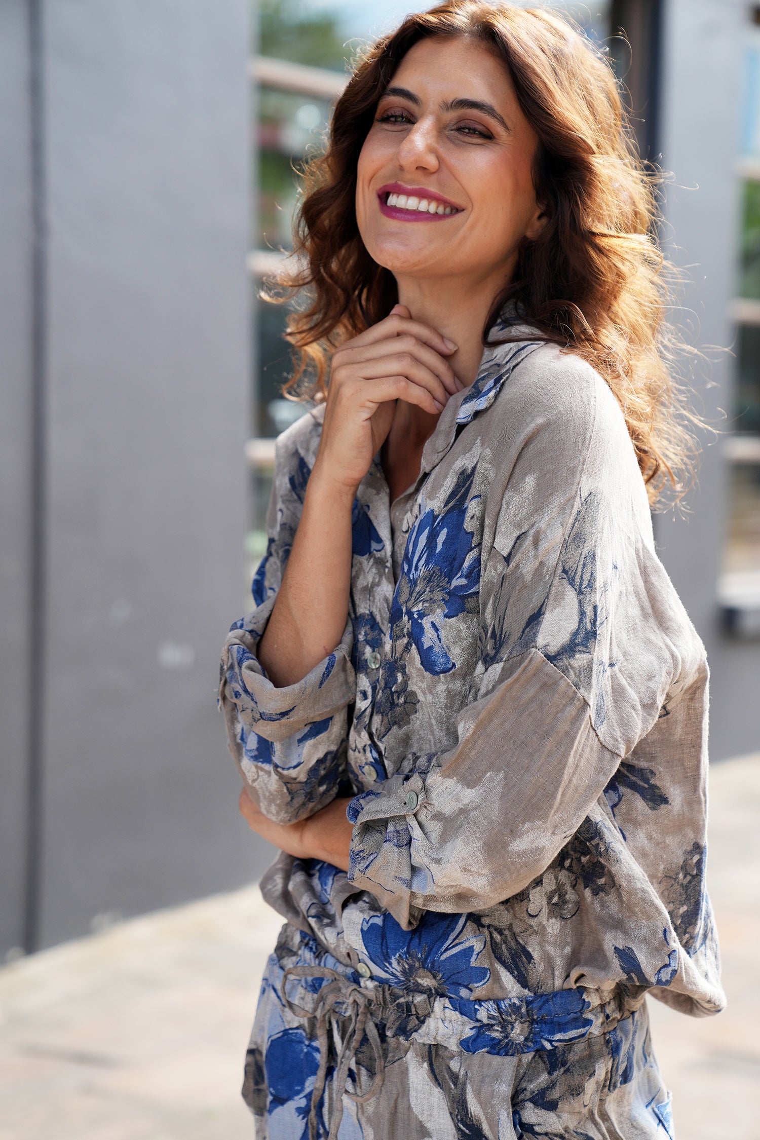Woman wearing a floral outfit standing outdoors.