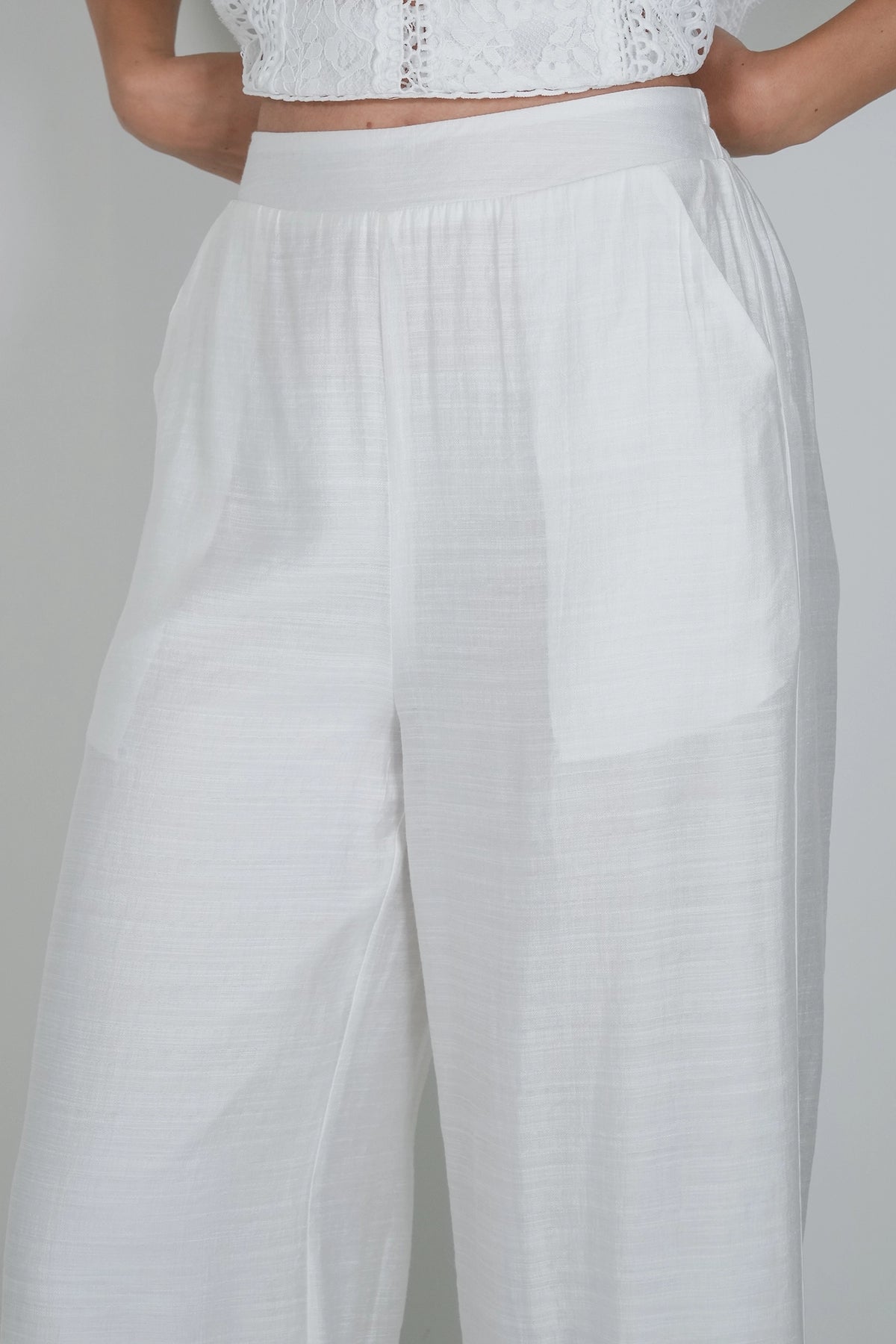 White wide-leg trousers with a high elastic waistband, shown on a model against a light gray background.