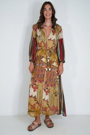 Woman wearing a patterned dress with long sleeves against a white background