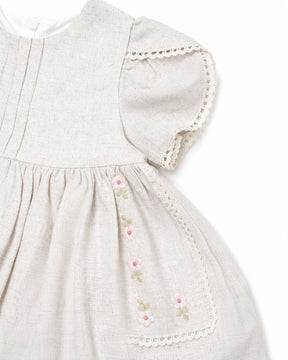 Light gray dress with floral embroidery and lace trim on a white background