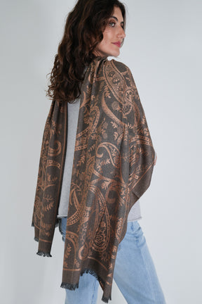 Woman wearing a patterned scarf on a plain background