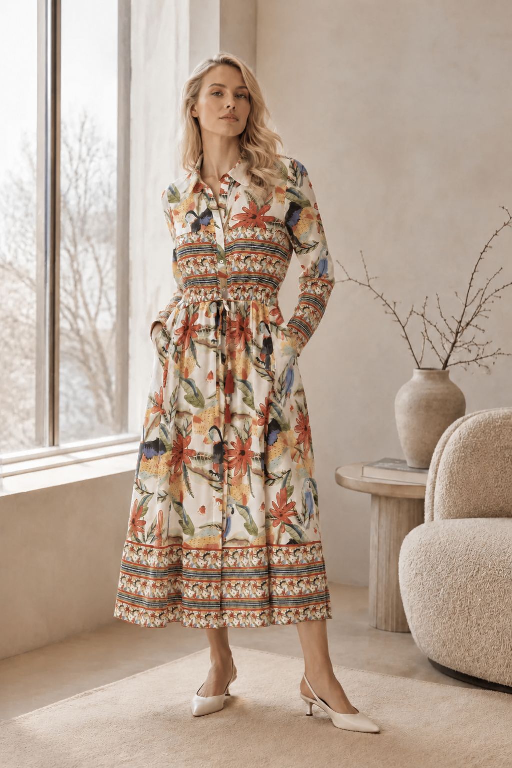 Woman in a floral dress standing in a room with a window and decorative elements.