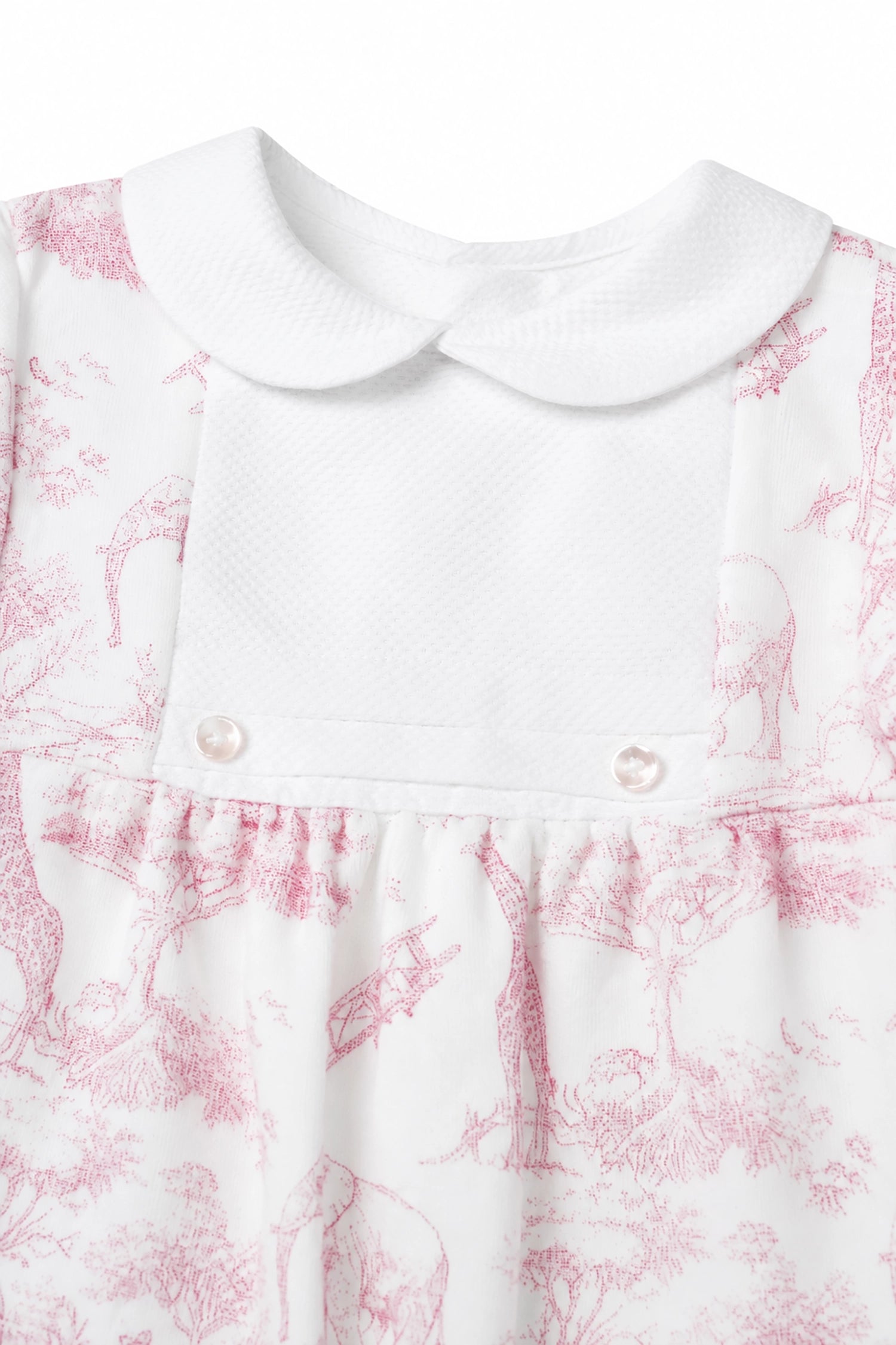 White dress with pink floral pattern and pearl buttons on a white background