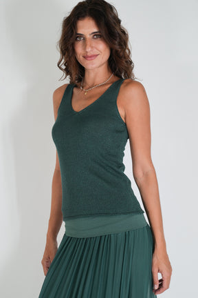 Woman wearing a green sleeveless top and skirt against a white background